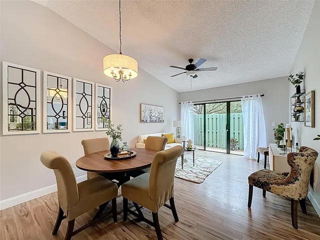 a dining room with furniture a chandelier and wooden floor