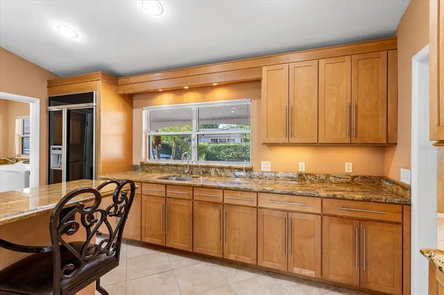 a dining hall with stainless steel appliances kitchen island granite countertop a table and chairs