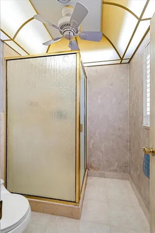 an empty room with a chandelier fan and windows