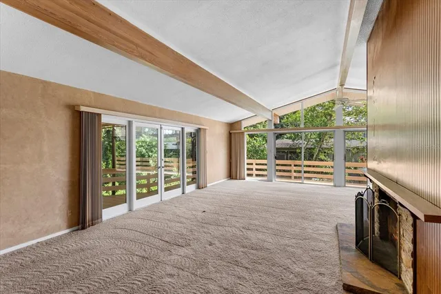a view of an empty room with a balcony and a window
