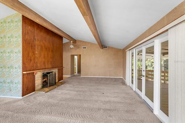 a view of an empty room with a window and stairs