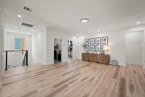 a view of a livingroom with wooden floor and kitchen space