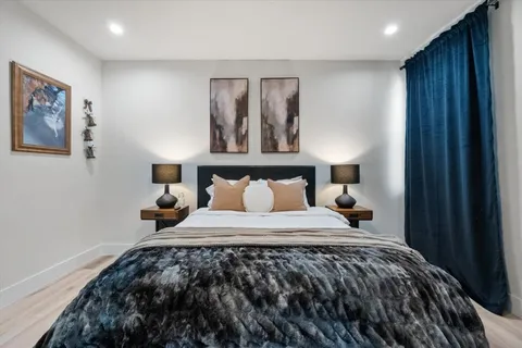 a bedroom with a large bed and painting on the wall