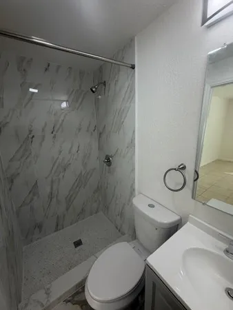 a bathroom with a sink toilet and shower
