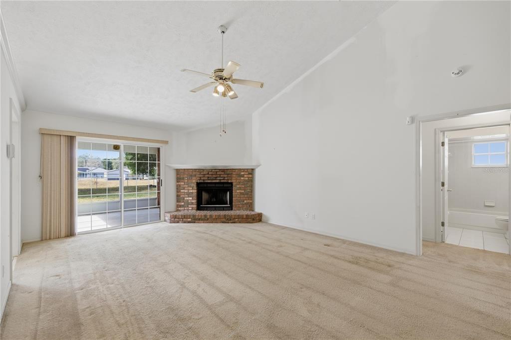 10660 Southwest 73rd Avenue Ocala, FL 34476 - Photo 9 of 37 a view of empty room with a fireplace and fan
