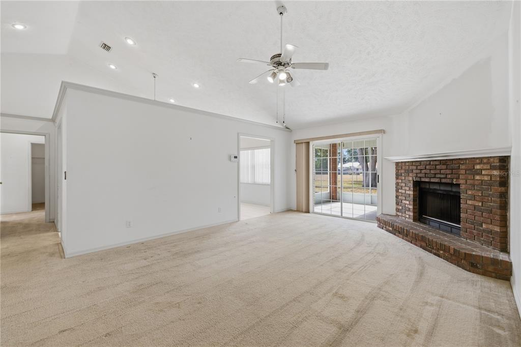 10660 Southwest 73rd Avenue Ocala, FL 34476 - Photo 10 of 37 a view of an empty room with chandelier fan and fire place