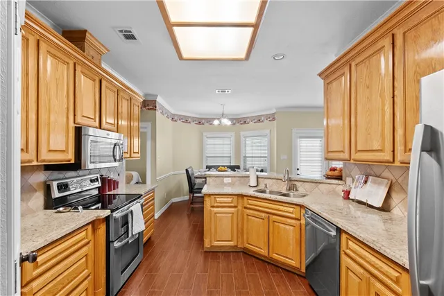 a kitchen with stainless steel appliances a sink a stove and a window