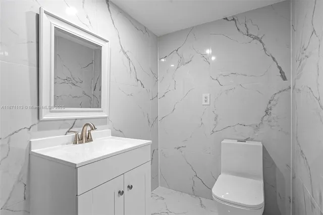 a bathroom with a toilet sink and mirror