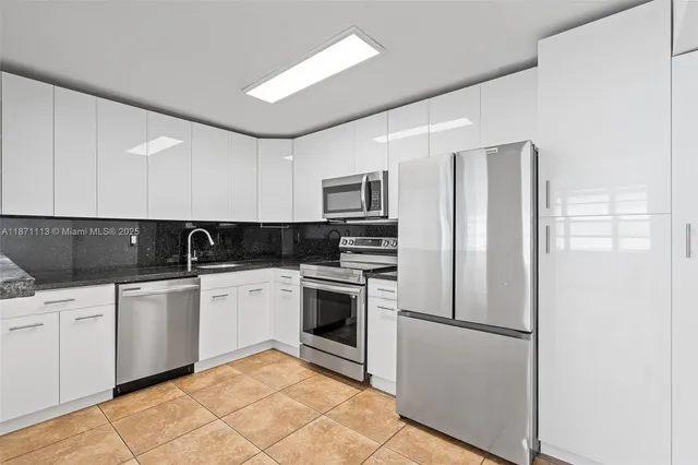 a kitchen with stainless steel appliances granite countertop a refrigerator sink and stove