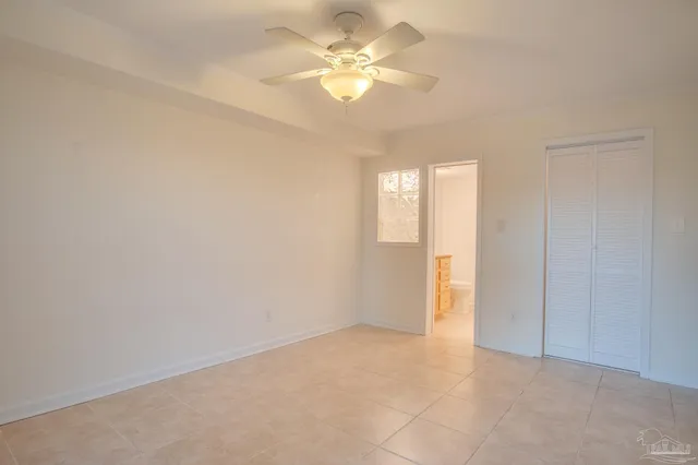 a bathroom with a granite countertop sink a toilet a window and shower