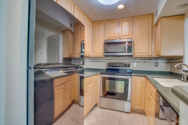 a kitchen with stainless steel appliances granite countertop a sink stove and microwave