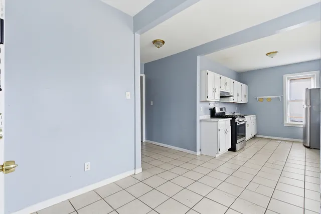 a kitchen with a refrigerator and white cabinets