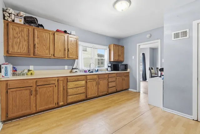 a kitchen with granite countertop a sink cabinets stainless steel appliances and a window
