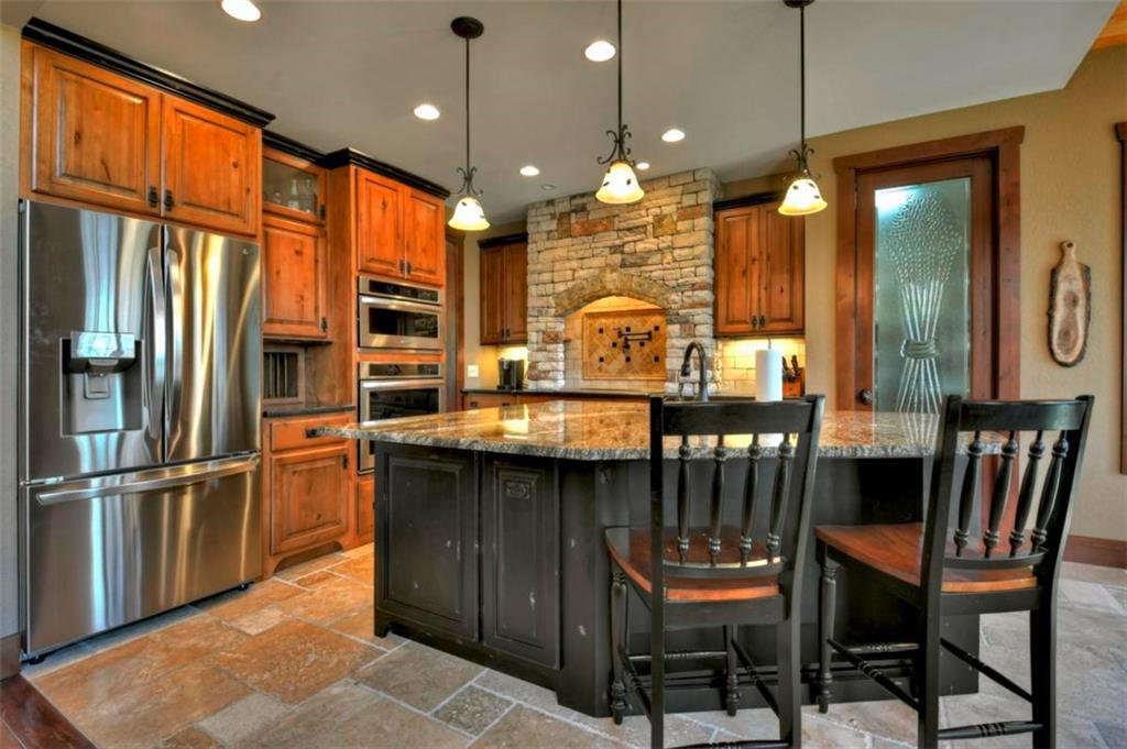 244 Wilderness Way Ellijay, GA 30536 - Photo 13 of 78 a kitchen with stainless steel appliances granite countertop a refrigerator a oven a sink and a dining table with chairs