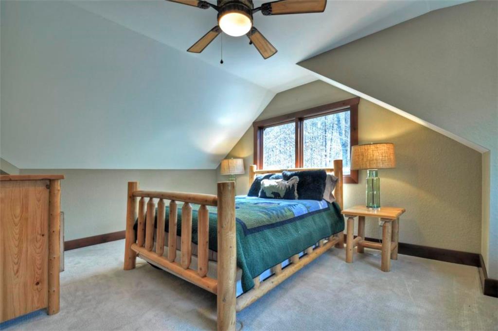 244 Wilderness Way Ellijay, GA 30536 - Photo 50 of 78 a bedroom with a bed and a chandelier