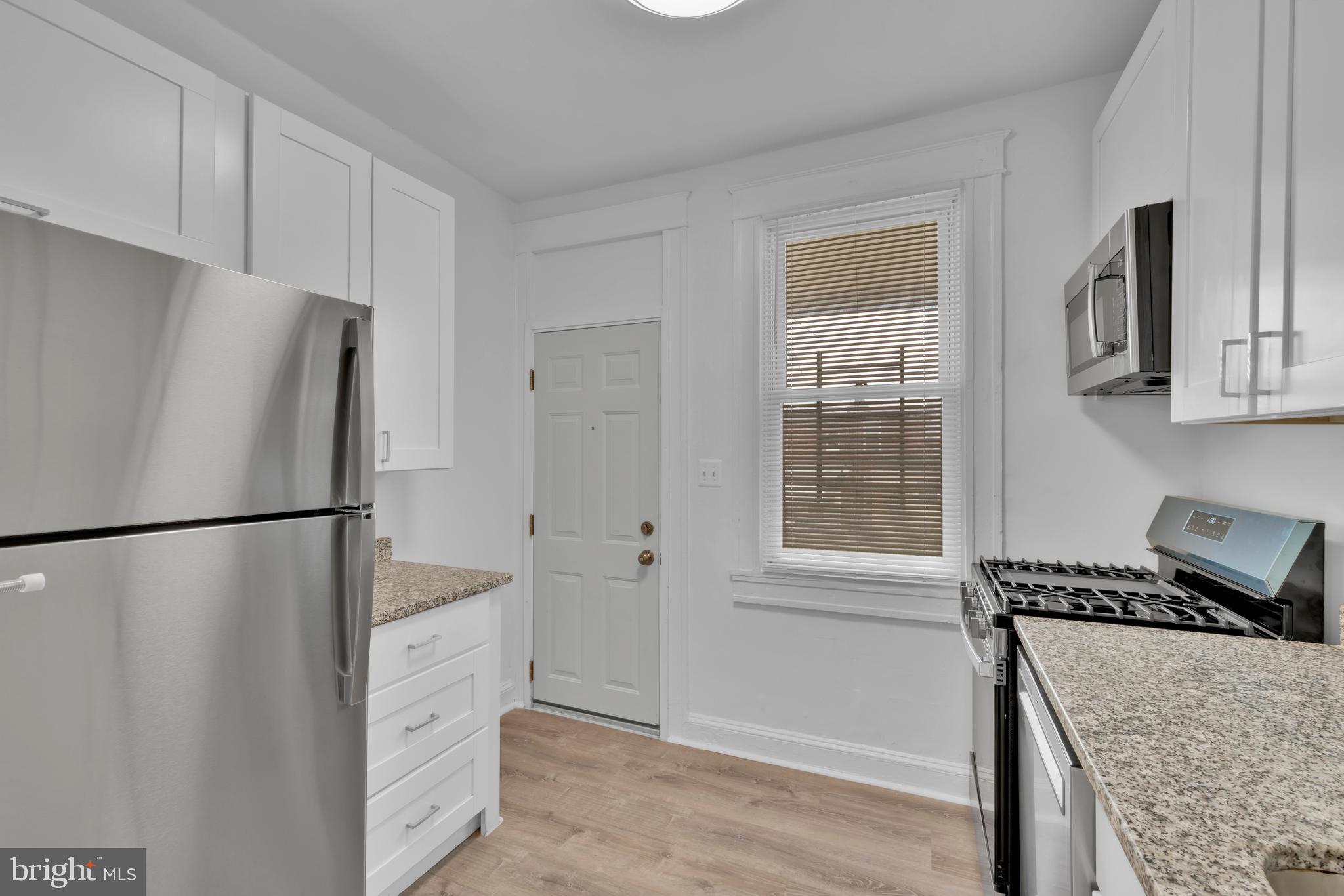 747 East 37th Street Baltimore, MD 21218 - Photo 19 of 53 a kitchen with granite countertop cabinets and refrigerator