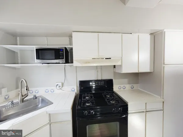 a kitchen with a sink stove and microwave