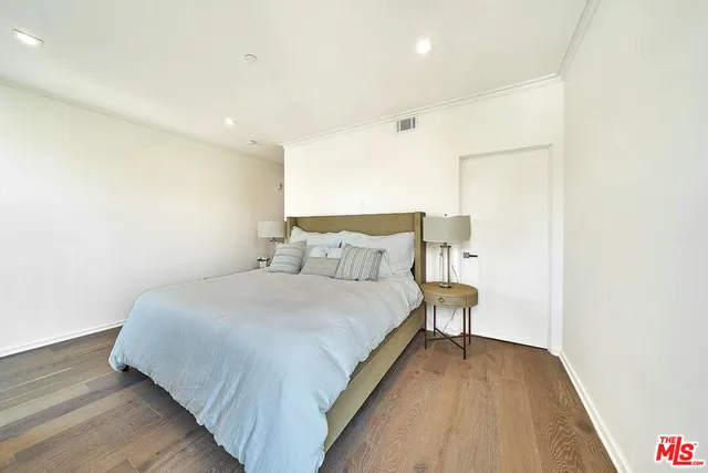a bed room with a bed and a wooden floor