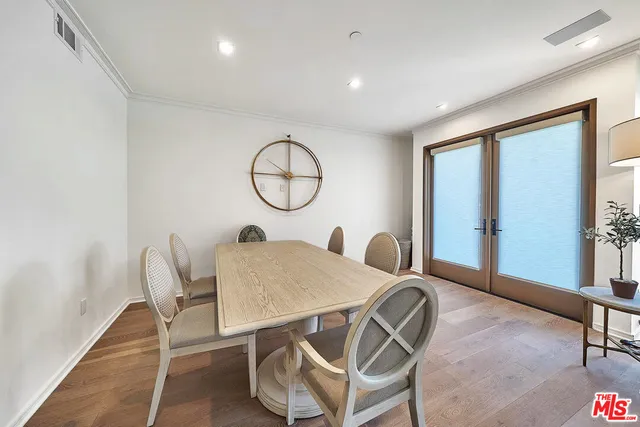 a view of a dining room and livingroom with furniture wooden floor and a rug