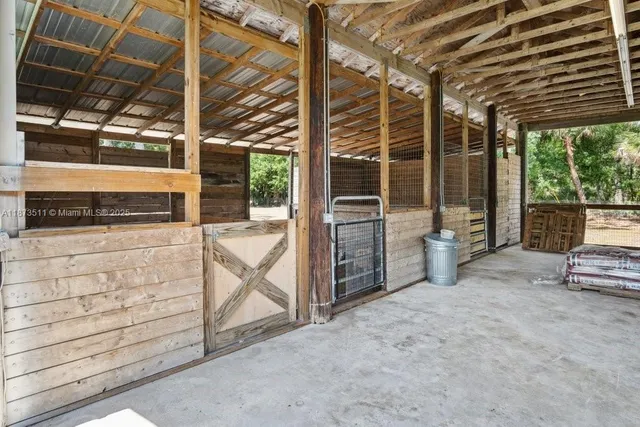a view of a patio with table and chairs and a barbeque with wooden fence