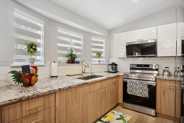 an aerial view of residential houses with outdoor space and trees