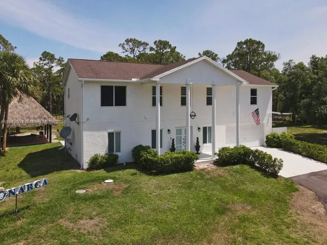 a view of a house with backyard and sitting area