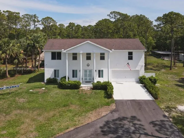 a front view of house with yard and trees