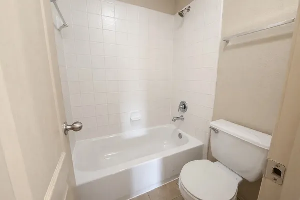 a white toilet sitting next to a bath tub