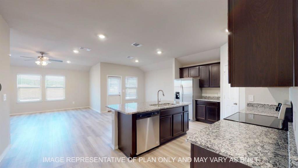 Open-concept living space with wood-finish flooring, recessed lighting, and a ceiling fan