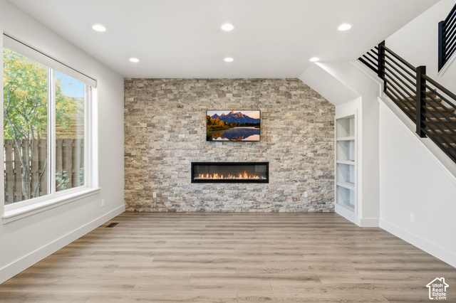1067 Station Loop Road Park City, UT 84098 - Photo 13 of 38 Wood-finish flooring, recessed lighting, expansive window, stone accent wall, and a built-in linear fireplace
