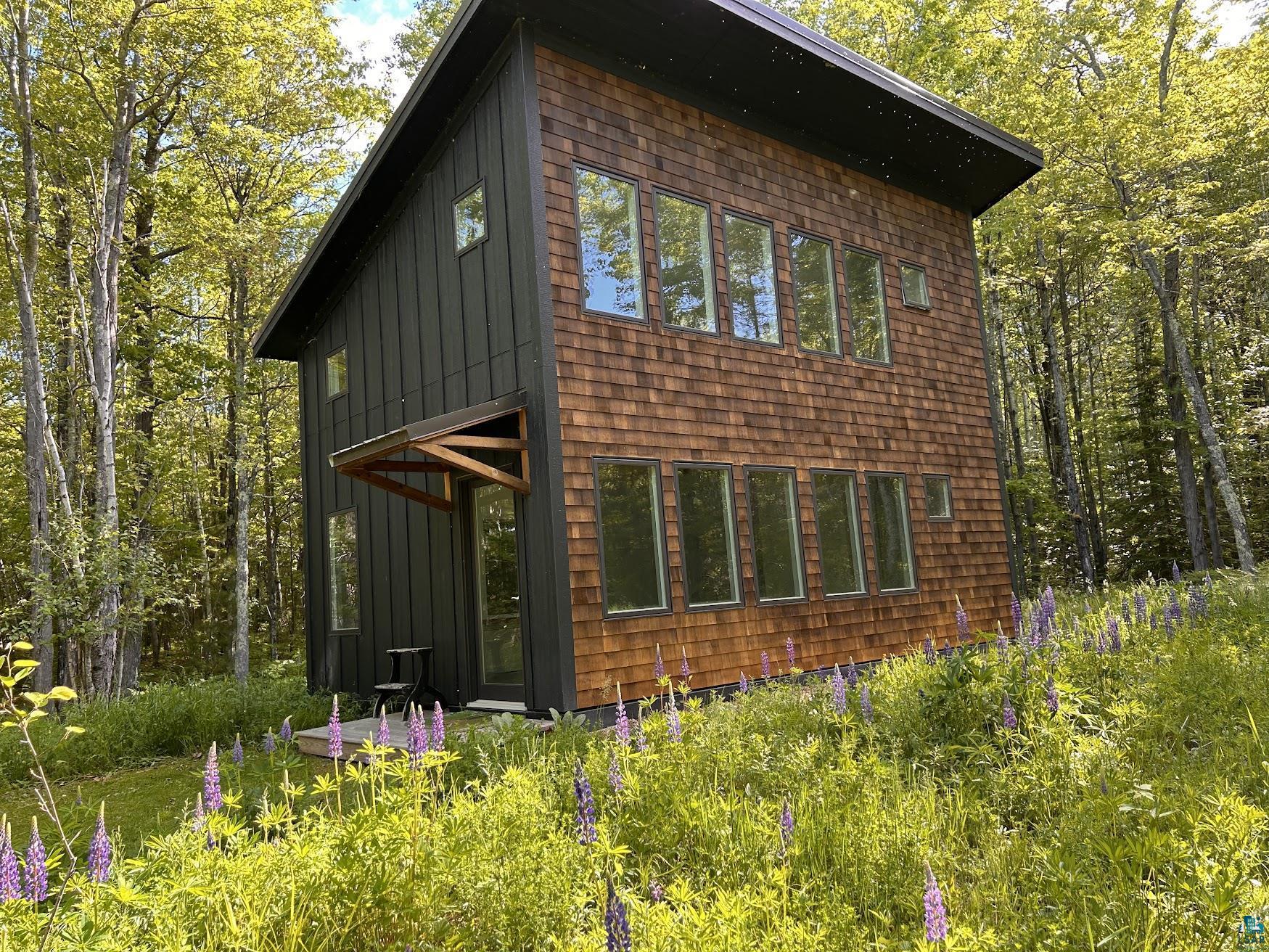 1596 North Shore Road La Pointe, WI 54850 - Photo 9 of 21 Modern architecture featuring a two-story design with cedar shake siding and dark vertical paneling