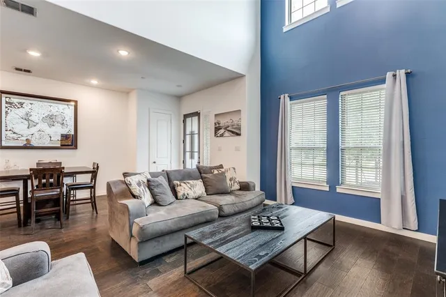 a living room with furniture a flat screen tv and a clock