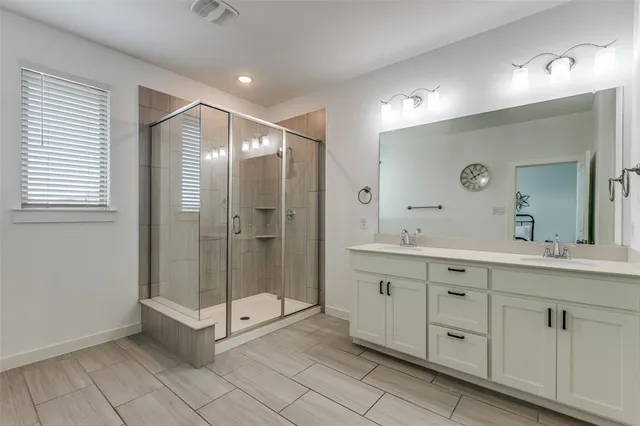 a bathroom with a shower and a sink a mirror