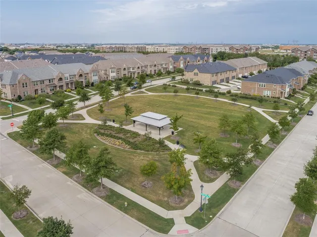 an aerial view of residential houses with outdoor space and street view