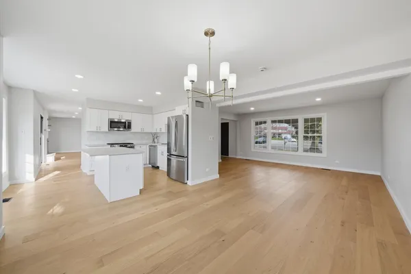 a view of a kitchen with a sink wooden floor and a large window