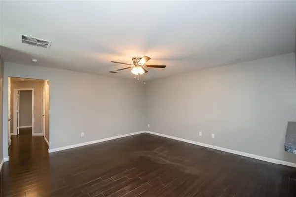 a view of a room with wooden floor and fan