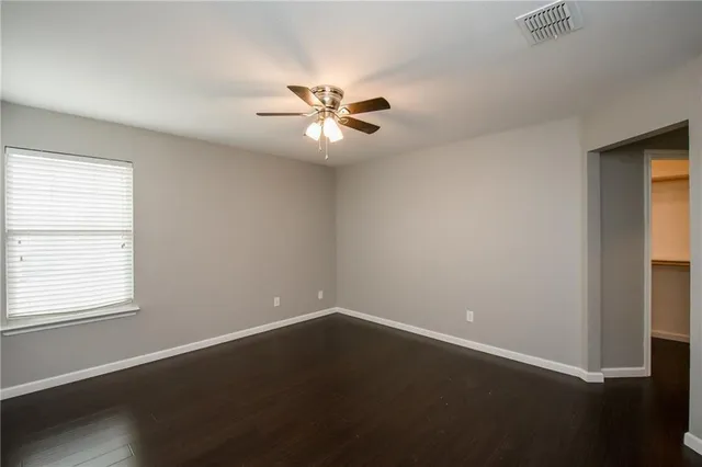 an empty room with a window and a fan