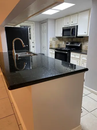 a kitchen with a sink a microwave and cabinets