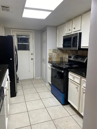a kitchen with stainless steel appliances granite countertop a stove a microwave and a refrigerator