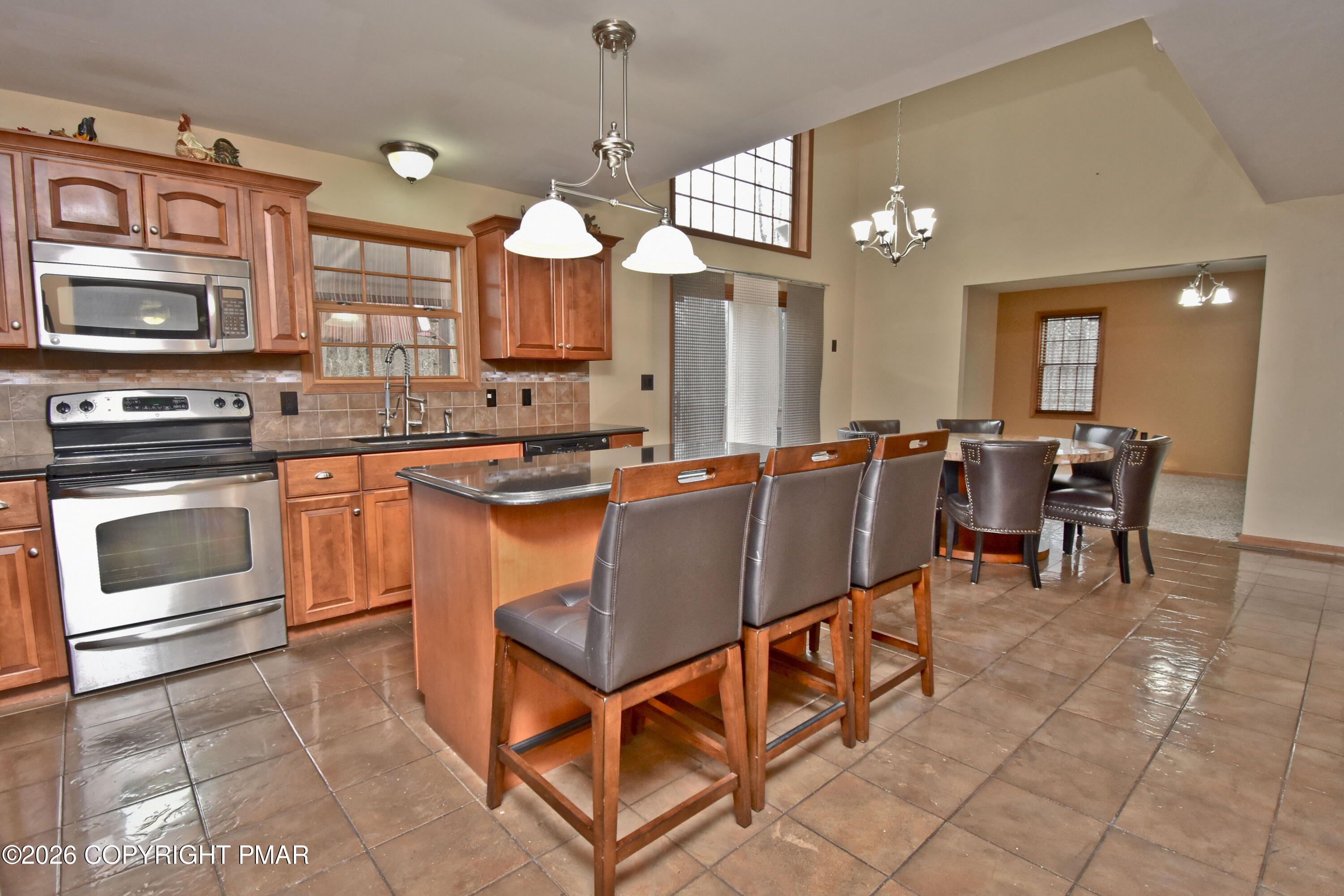 131 Canterbury Road Bushkill, PA 18324 - Photo 18 of 65 a kitchen with stainless steel appliances granite countertop a stove a sink a dining table and chairs
