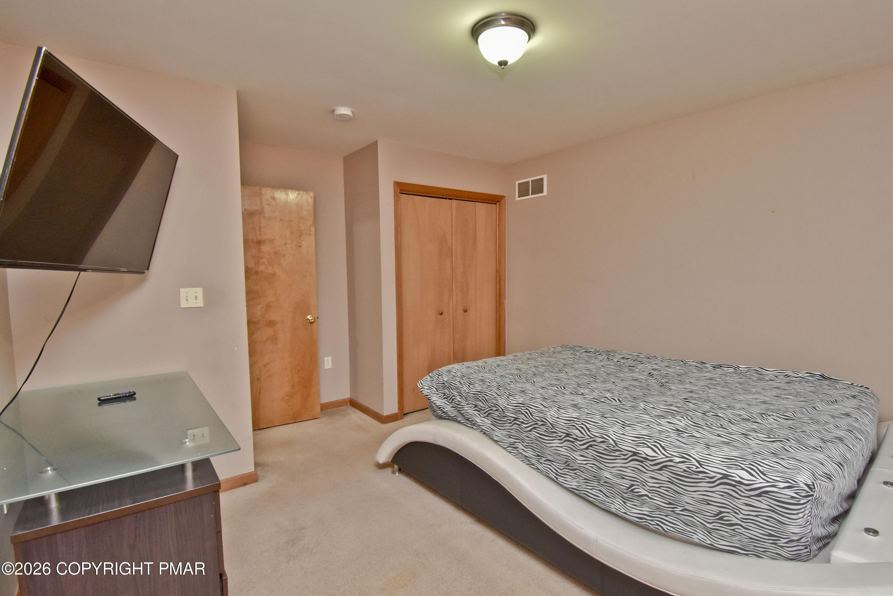 131 Canterbury Road Bushkill, PA 18324 - Photo 34 of 65 a bedroom with a bed and a flat screen tv