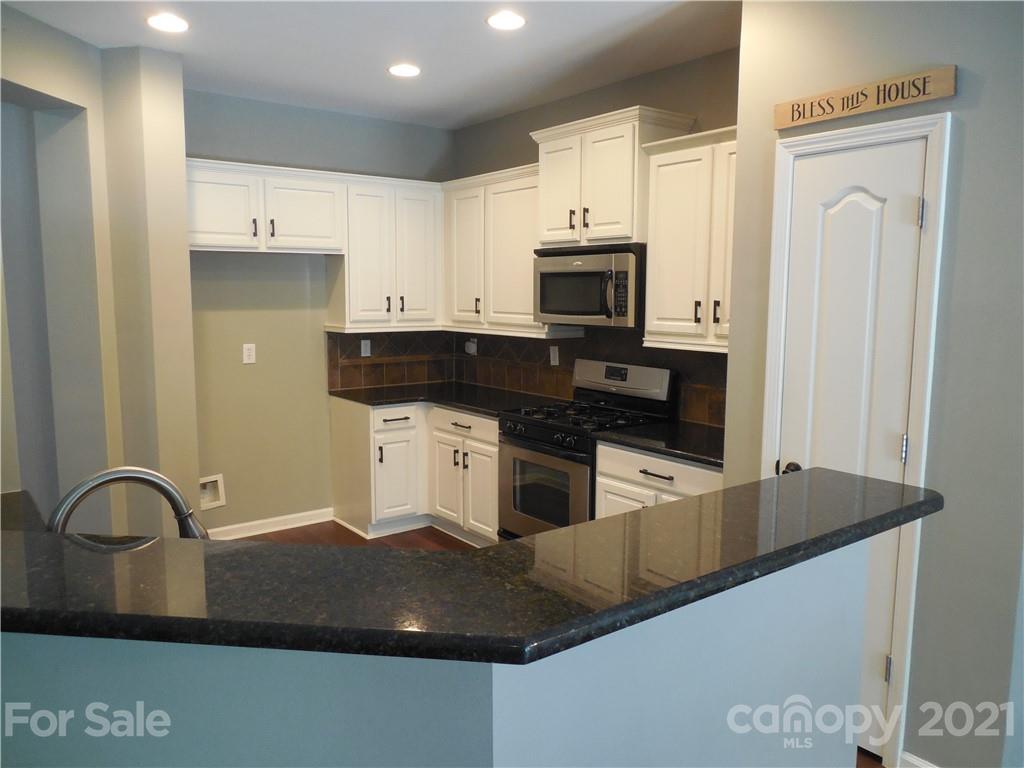 7015 Sedgewick Road Indian Trail, NC 28079 - Photo 12 of 14 a kitchen with stainless steel appliances granite countertop a sink a stove and a refrigerator