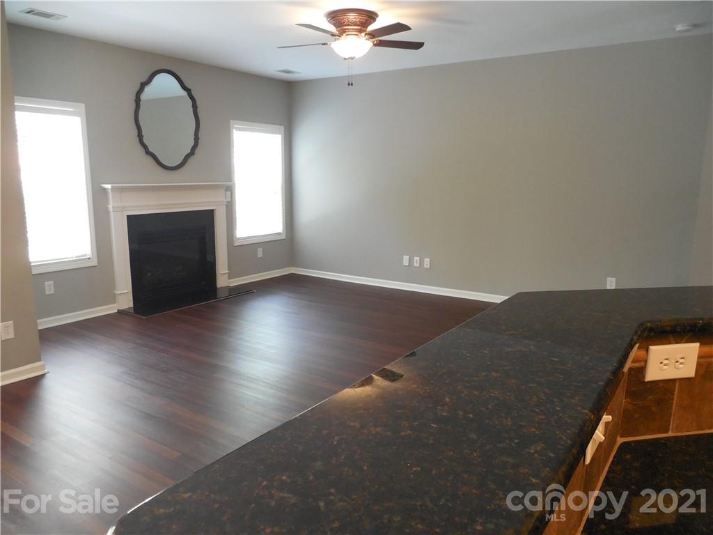 7015 Sedgewick Road Indian Trail, NC 28079 - Photo 13 of 14 an empty room with wooden floor fireplace and windows