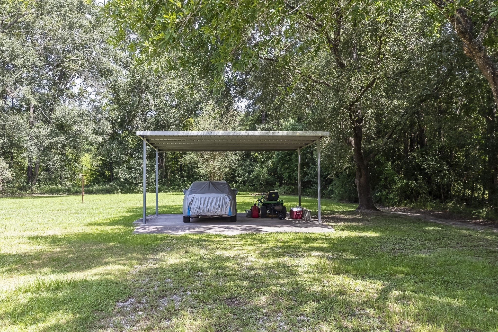 208 County Road 308 Cleveland, TX 77327 - Photo 25 of 32 a backyard of a house with table and chairs under an umbrella