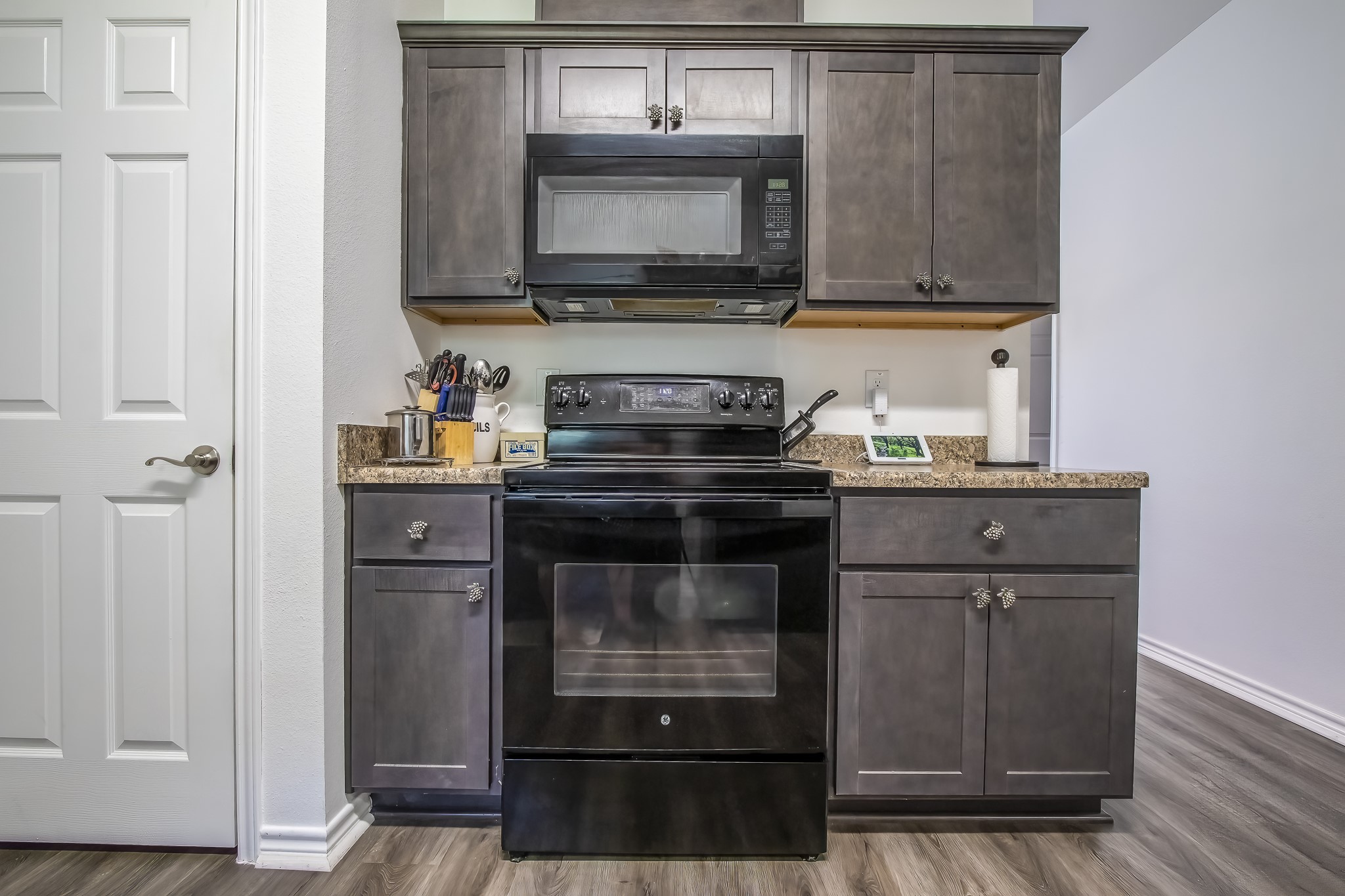 208 County Road 308 Cleveland, TX 77327 - Photo 10 of 32 a kitchen with granite countertop a stove and a microwave