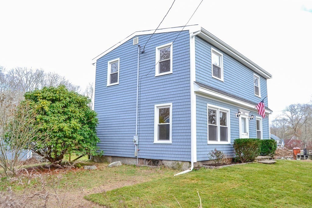 1031 Old Fall River Road Dartmouth, MA 02747 - Photo 26 of 32 a brick house that has a small yard plants and trees in the background