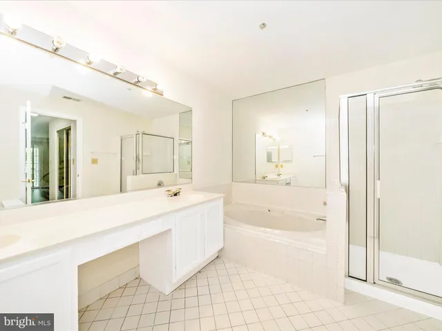 a spacious bathroom with a bathtub sink and mirror