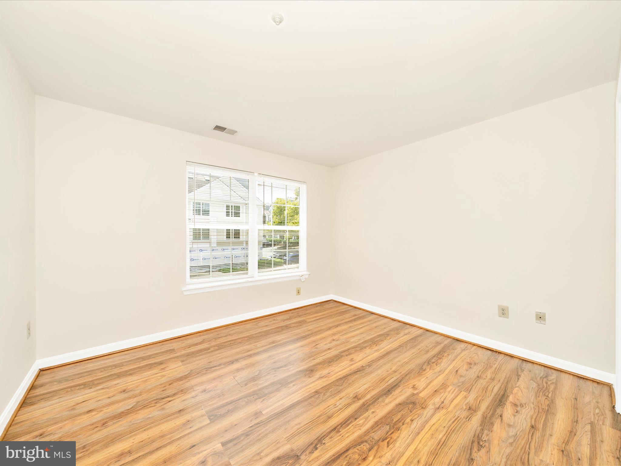 122 Kendrick Place, Unit 24 Gaithersburg, MD 20878 - Photo 27 of 43 a view of an empty room with wooden floor and a window
