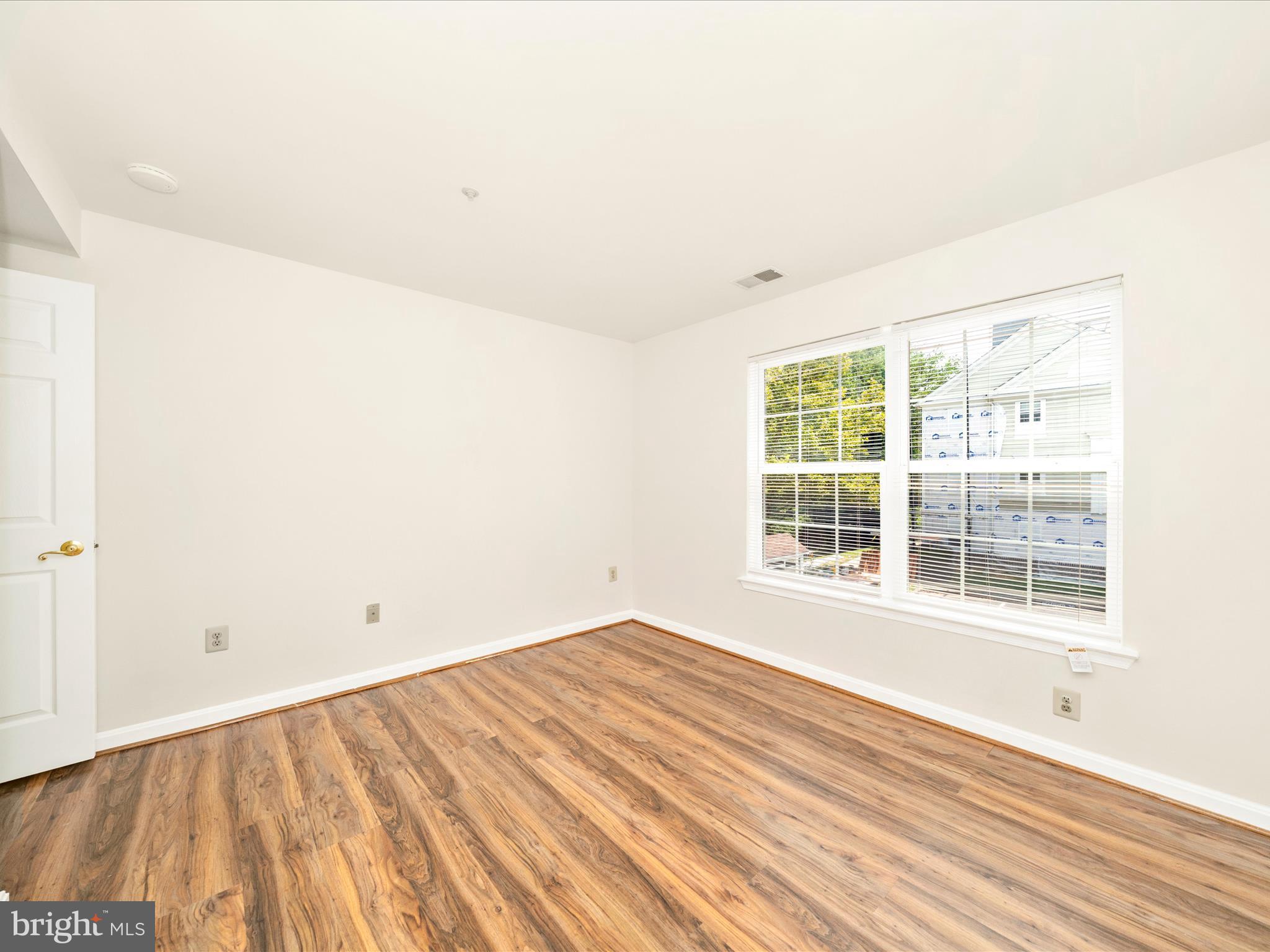 122 Kendrick Place, Unit 24 Gaithersburg, MD 20878 - Photo 28 of 43 an empty room with wooden floor and windows