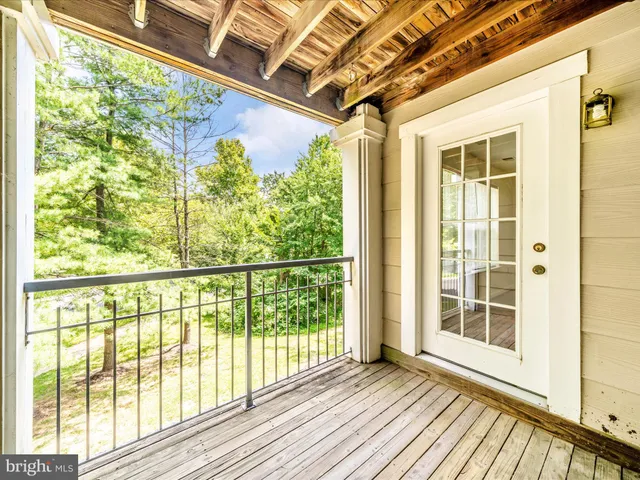 a view of a porch with wooden floor and door